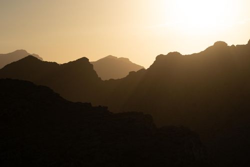 Free Captivating mountain silhouettes under a golden sunset sky in Ibiza, Spain. Stock Photo