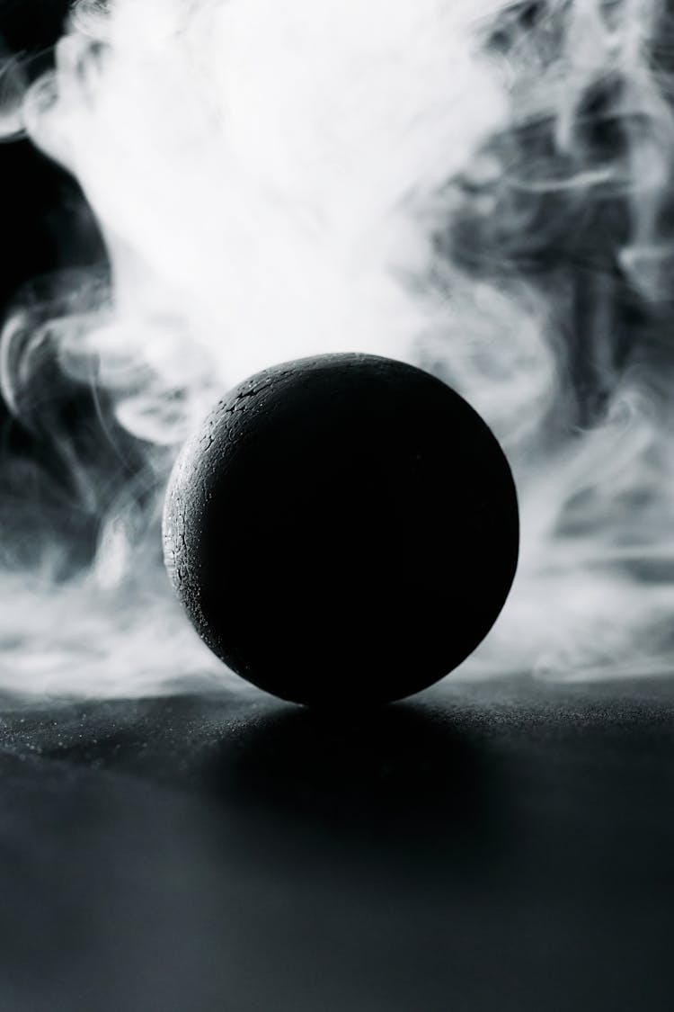 A Black Ball Against White Smoke