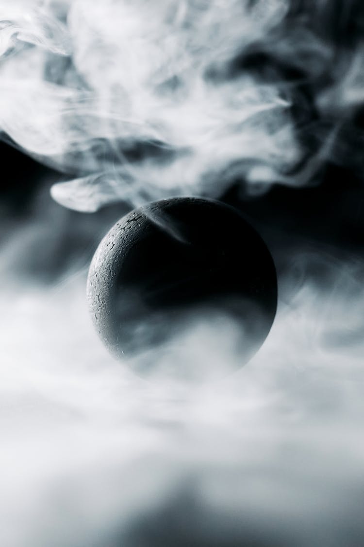 A Black Ball Surrounded By Smoke