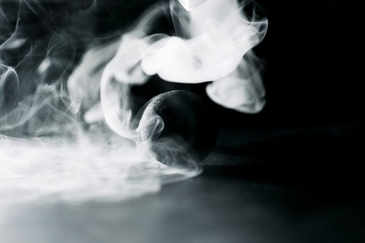 A Black Ball Surrounded By Smoke