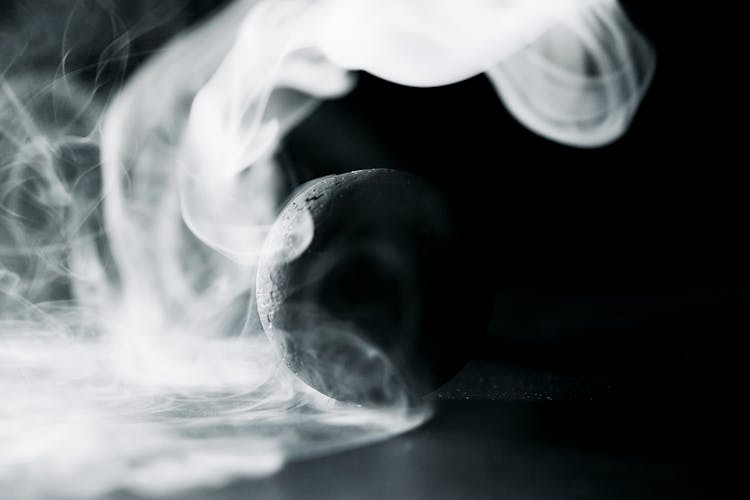 A Black Ball Surrounded By Smoke