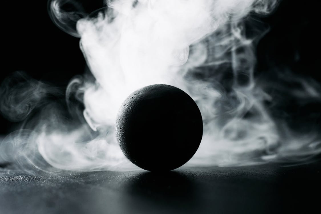 A Black Ball Against White Smoke