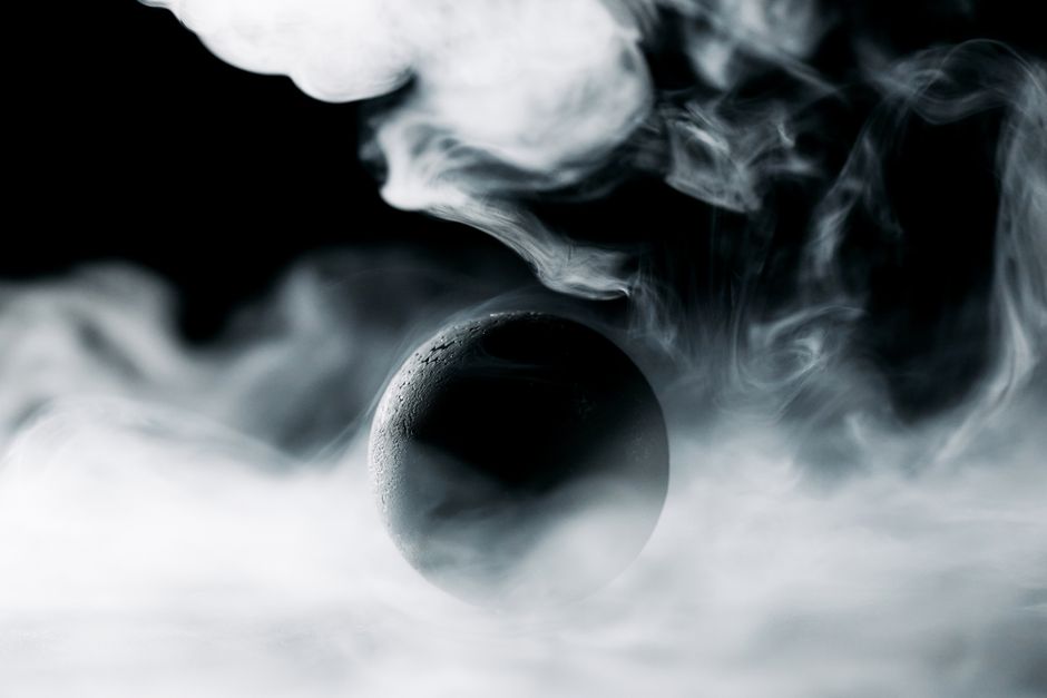 A captivating abstract photo with a sphere enveloped in mysterious swirling smoke.