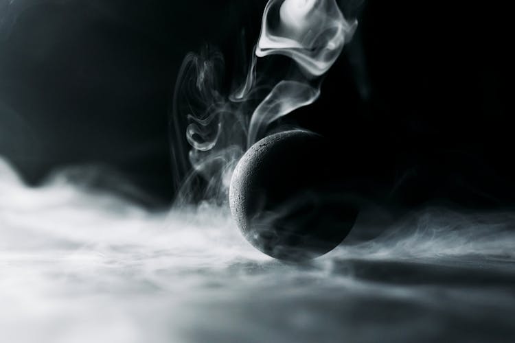 A Black Ball Surrounded By Smoke