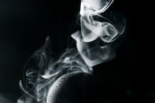 Artistic close-up of swirling smoke around a sphere, creating a mysterious visual effect.