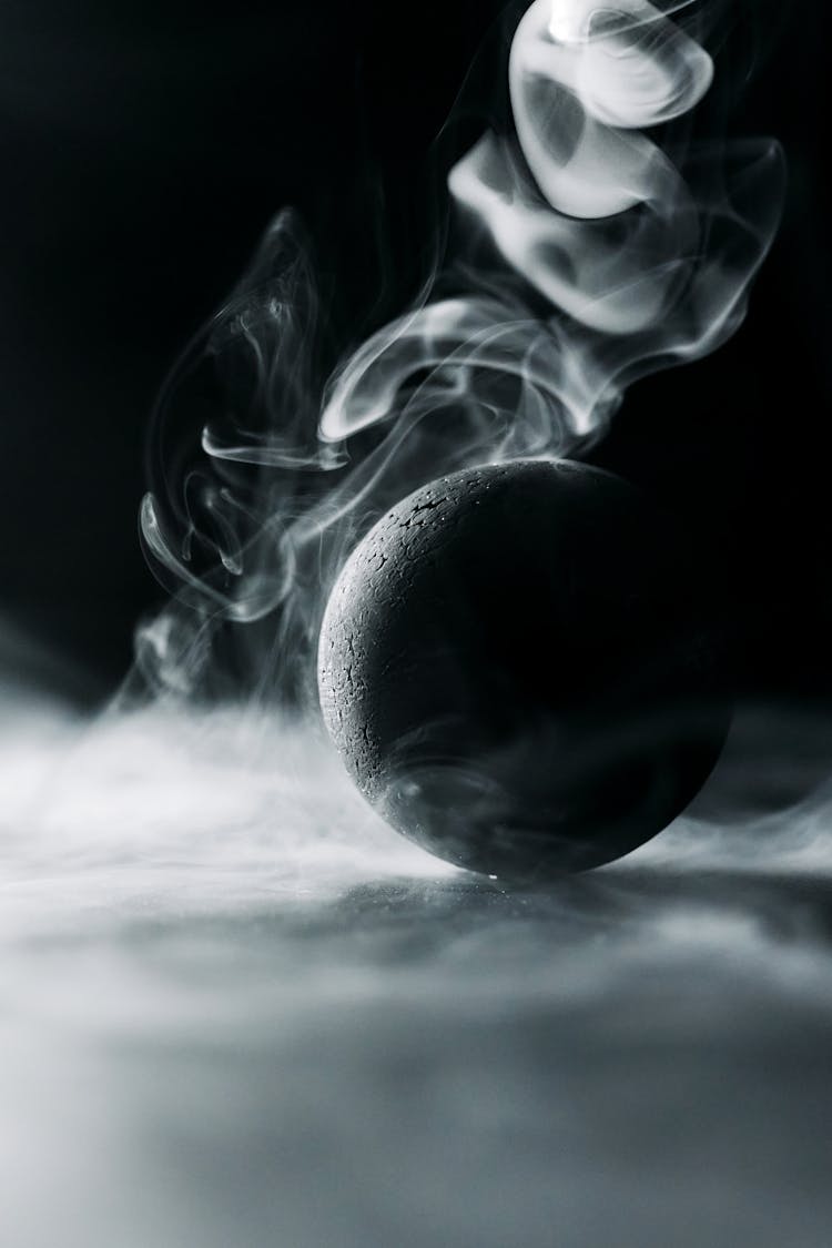 A Black Ball Surrounded By Smoke