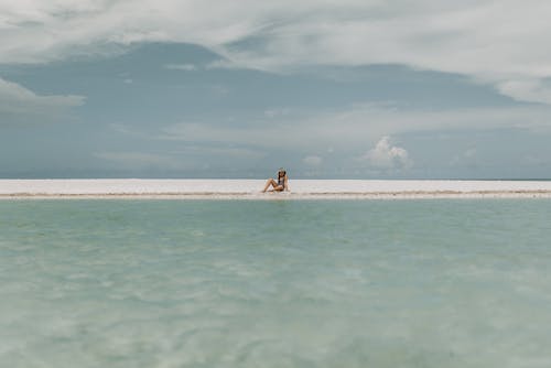 무료 하얀 모래에 앉아있는 사람 스톡 사진