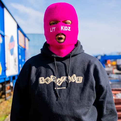 A Person Wearing a Pink Baclava Mask and Black Hoodie