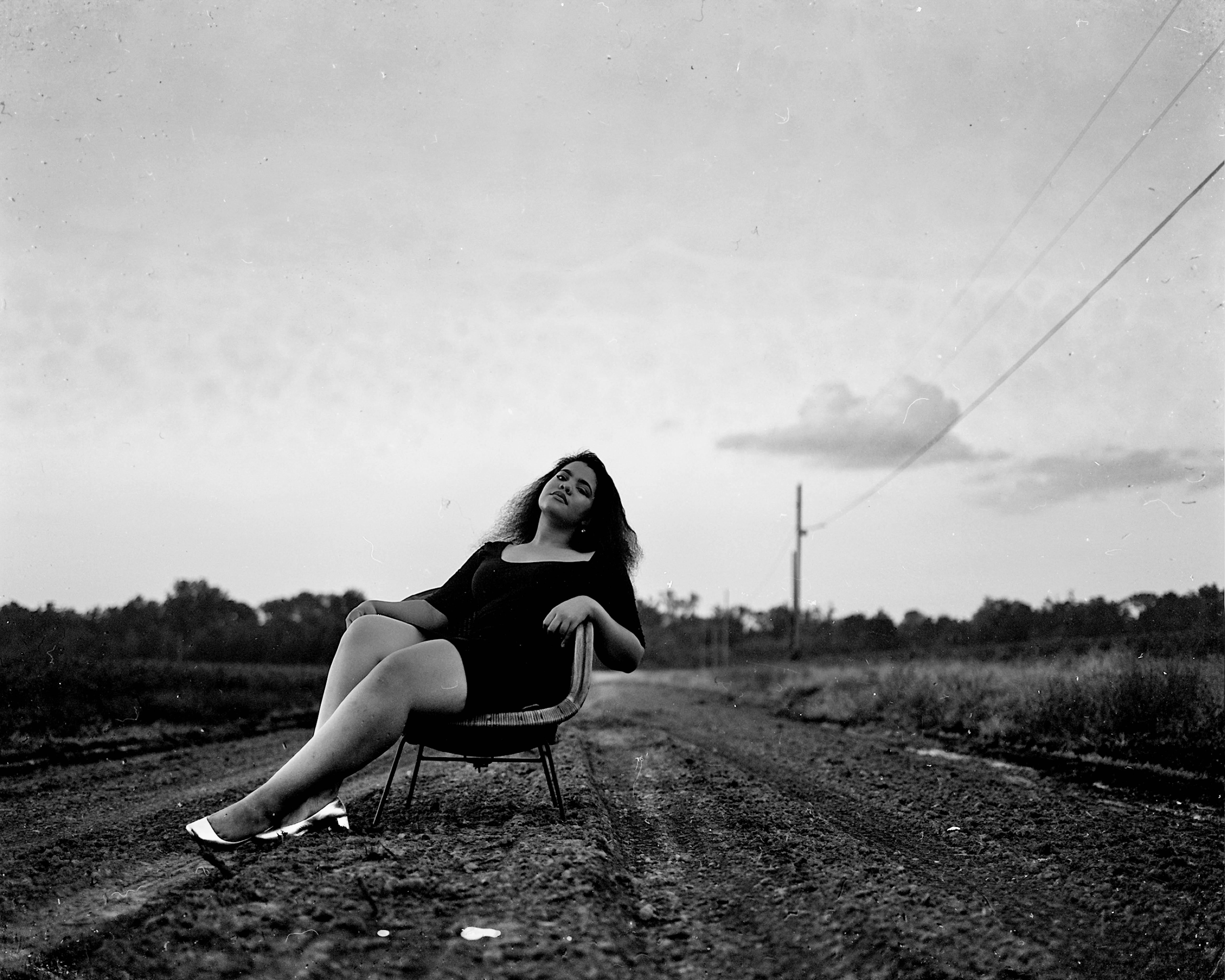Black and White Photography of Woman on Chair on Road