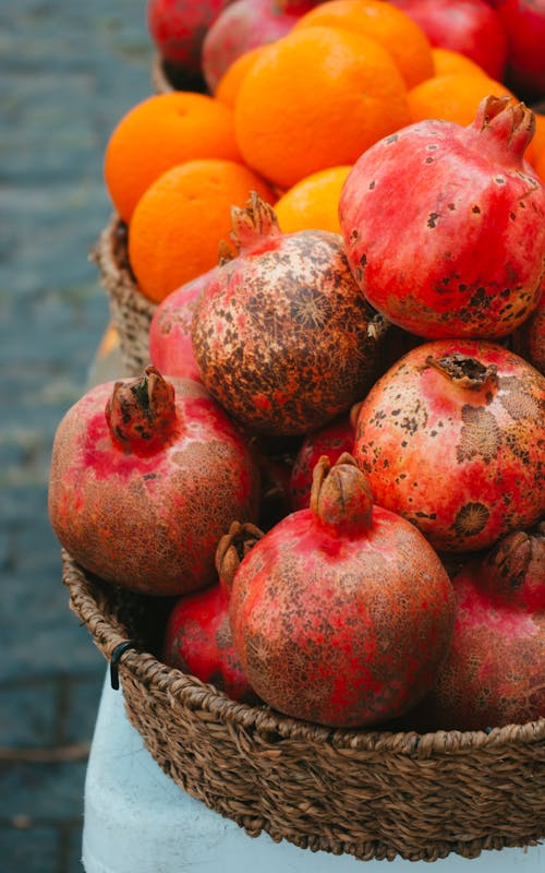 Close-Up Photo of Red Pomegranates in a Basket