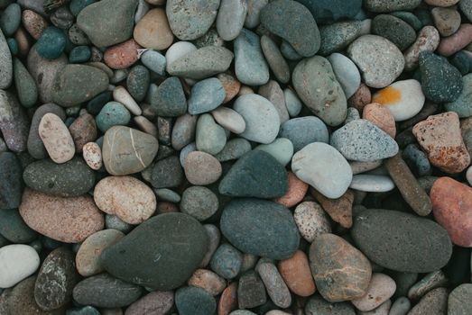 Texture-rich close-up of smooth pebbles in various colors, ideal for background use.