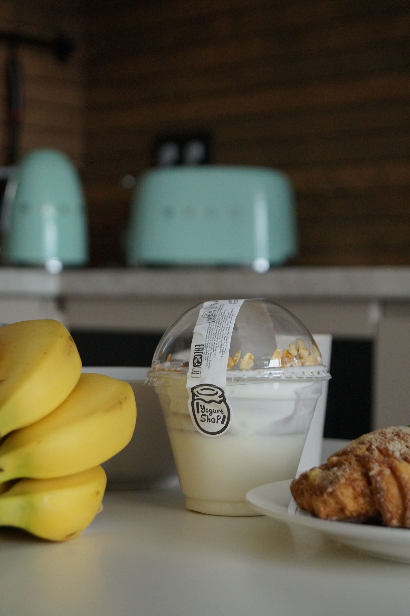 Yogurt in a plastic container served with a clean spoon at breakfast