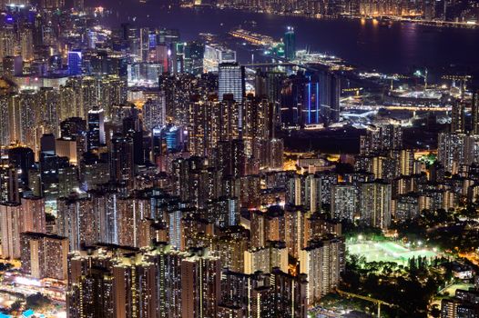 A breathtaking aerial view of Hong Kong's cityscape at night, showcasing modern skyscrapers and vibrant lights.