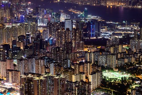 Free A breathtaking aerial view of Hong Kong's cityscape at night, showcasing modern skyscrapers and vibrant lights. Stock Photo