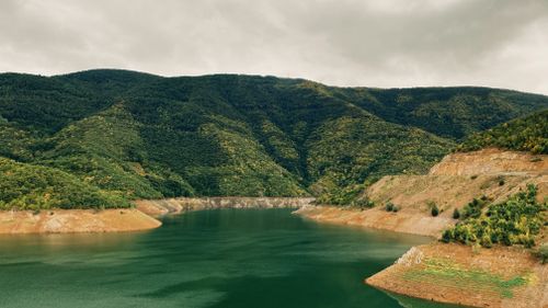 Free A scenic view of lush green mountains and a tranquil river in Mesudiye, Ordu, Turkey. Stock Photo