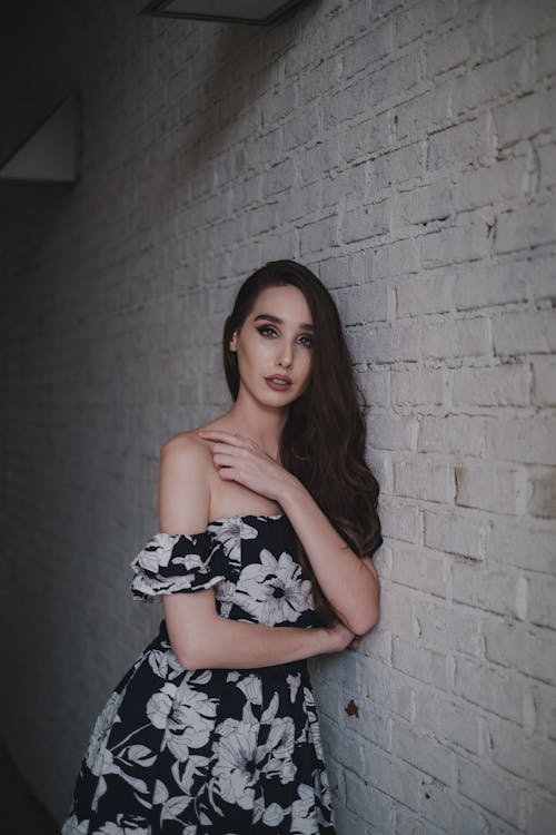 Free A Woman in Floral Dress Leaning on the Wall Stock Photo