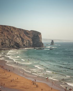 Aerial view of a picturesque beach and cliffs in Aljezur, Portugal showcasing summer activities.