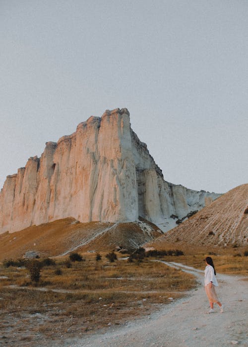 Woman walking, looking at cliff