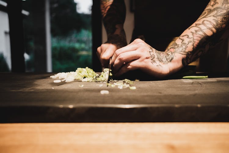 A Person Slicing Scallions