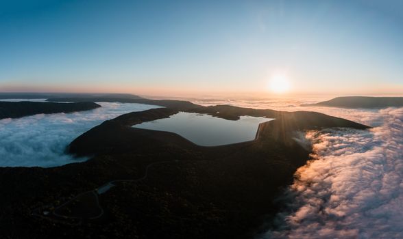 Stunning aerial view of a serene mountain lake with clouds at sunrise in Tennessee.