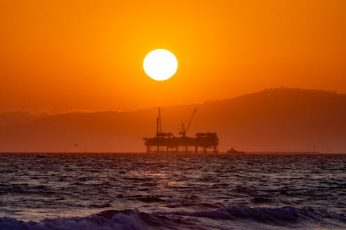 Sun on Clear, Yellow Sky over Oil Platform at Sunset