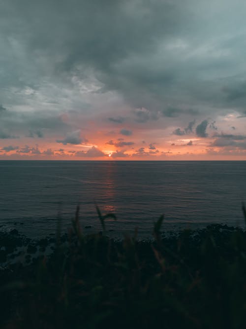 Body of Water Under Cloudy Sky