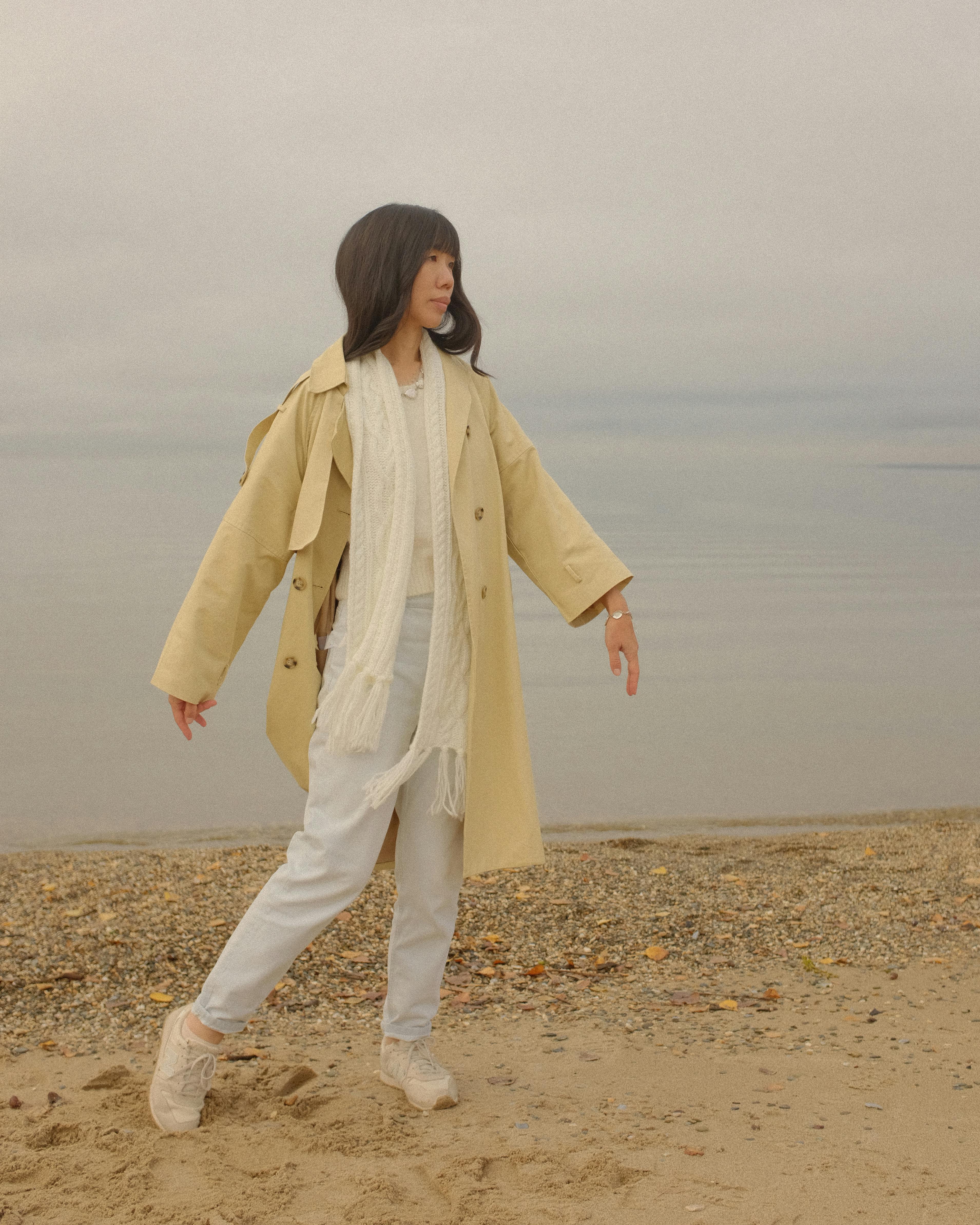 Photo of a Woman in a Coat Near the Beach · Free Stock Photo