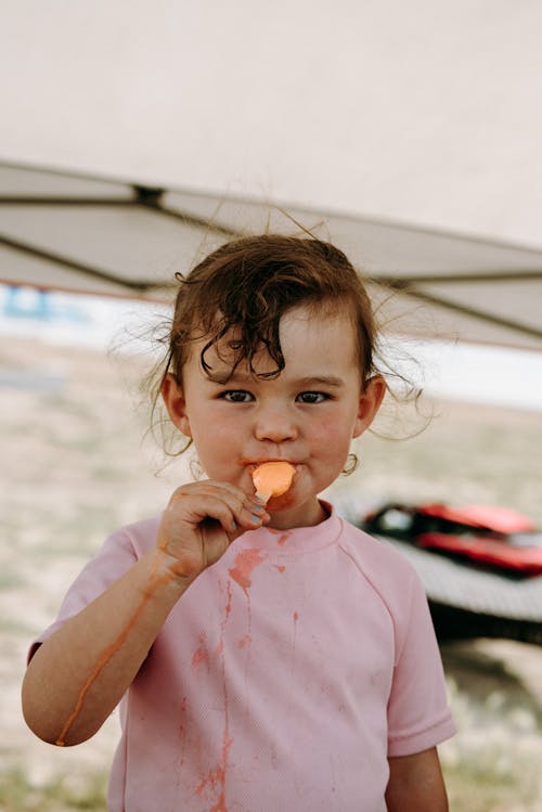 Free Close-Up Photo of a Cute Kid in a Pink Shirt Eating Ice Cream Stock Photo