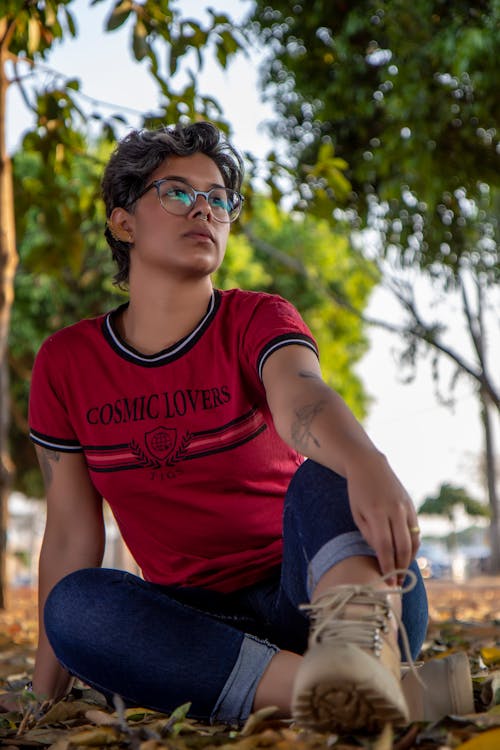 Woman in Red Crew Neck T Shirt Sitting on Ground 