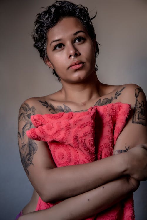 A Tattooed Woman Covering Her Body with Bath Towel