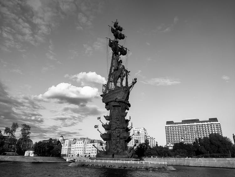 Statue Of Sailor On Ship In City In Black And White