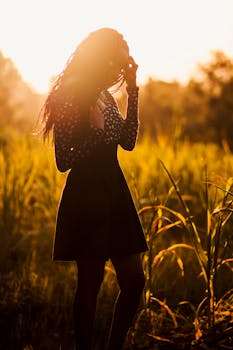 在肯尼亚基安布的草地上，一名妇女正享受着宁静的日落