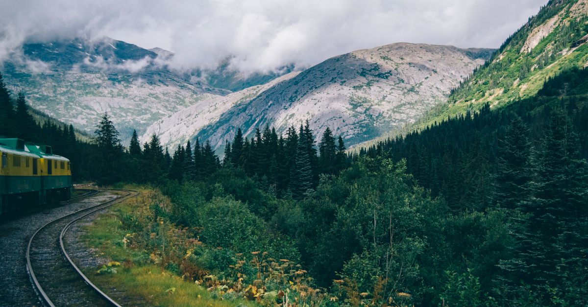 A train winding through a mountain landscape, with a caption about overland travel