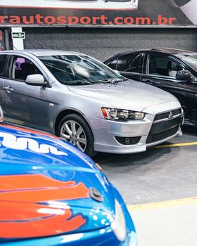 A stylish gray car parked indoors in a showroom, showcasing modern design.