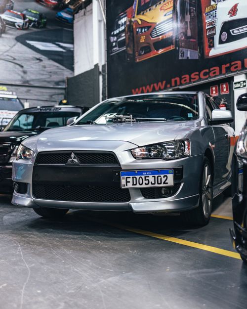 Free Close-up shot of a Mitsubishi car on display at an indoor auto show with other vehicles. Stock Photo