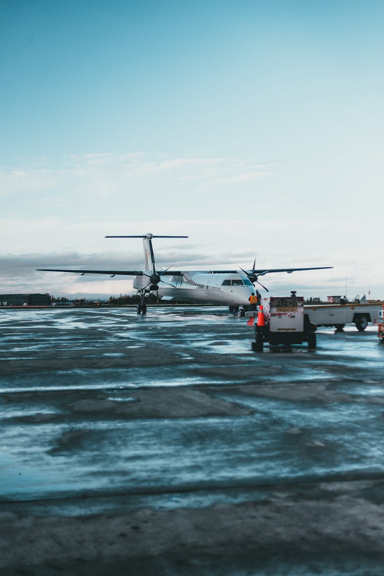 White Airplane Parked On A Wet Ground 