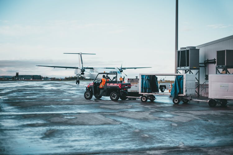 Man Driving Luggage Cart On Airports Tarmac