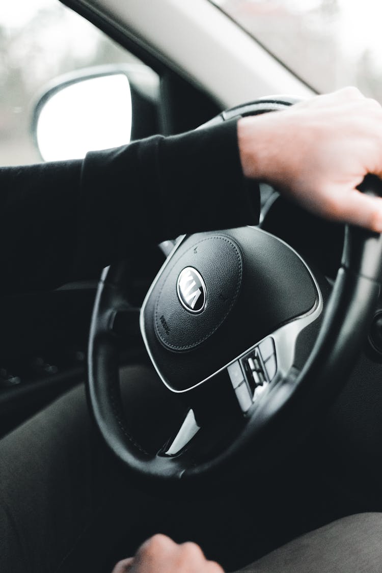 Close-Up Photo Of A Person's Hands Driving A Car