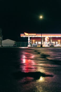 Mysterious gas station lit up during the night, evoking a liminal space atmosphere.