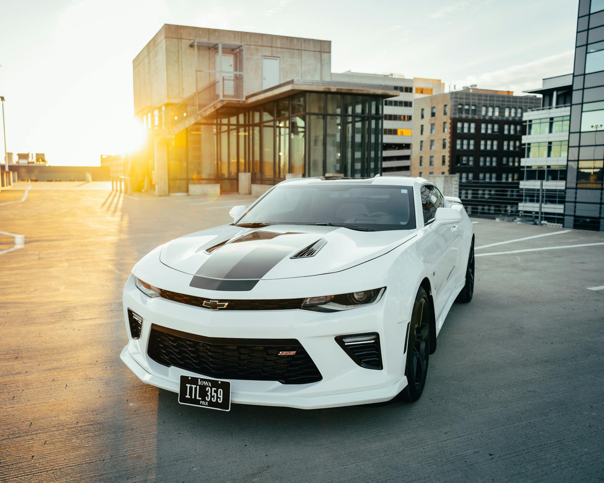 White Chevrolet Camaro parked in Des Moines with a warm sunset glow.