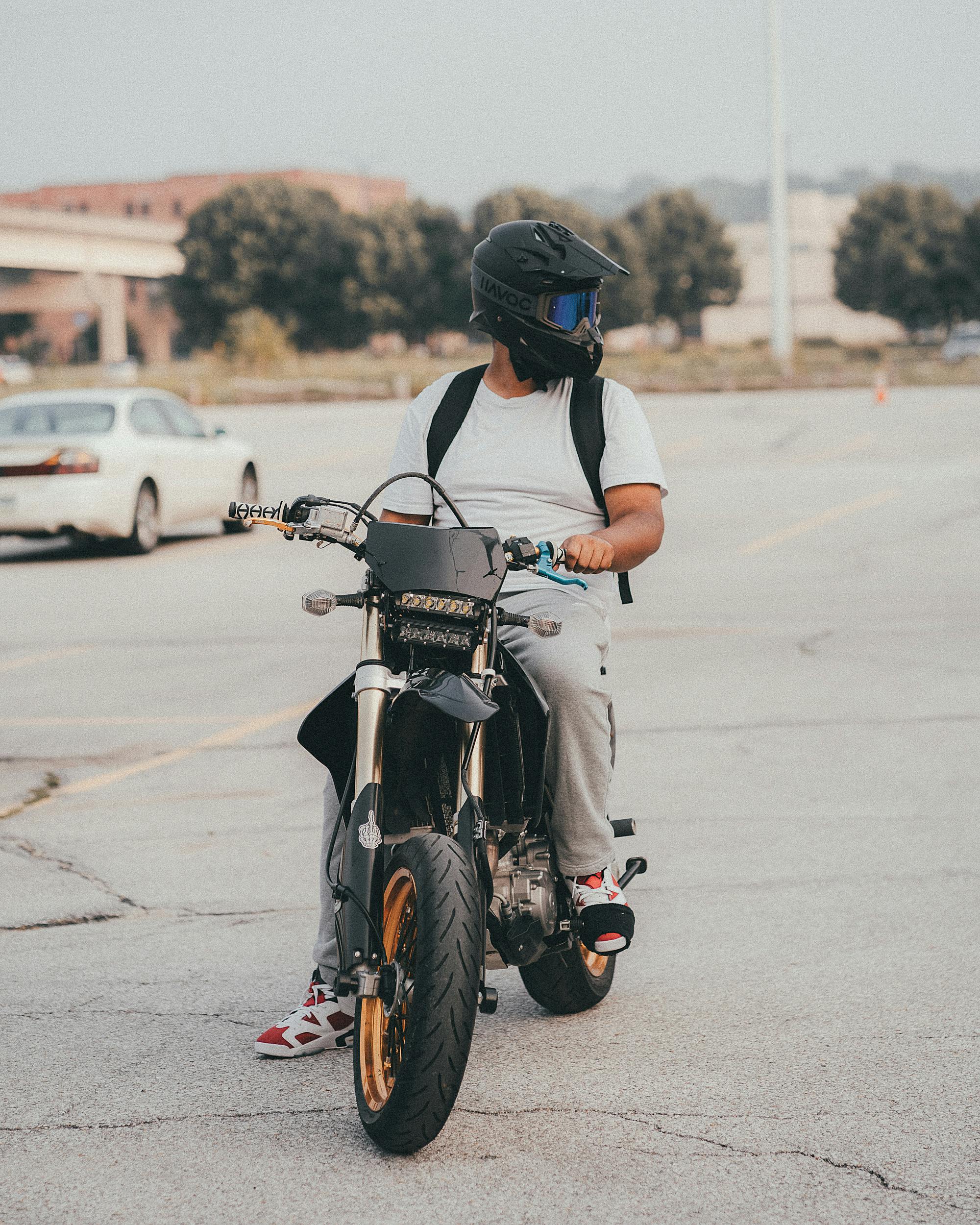 man in white crew neck t shirt sitting on motorcycle