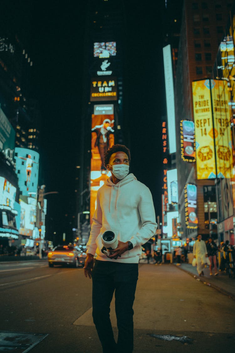 Male Pedestrian Wearing A Protective Face Mask At Night