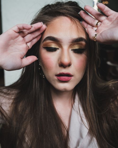 Free Close-up portrait featuring a woman with striking makeup, emphasizing her eyes and elegant style. Stock Photo