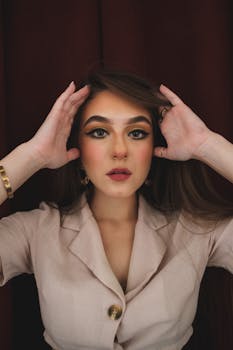 Close-up portrait of a woman with striking makeup and posing indoors.