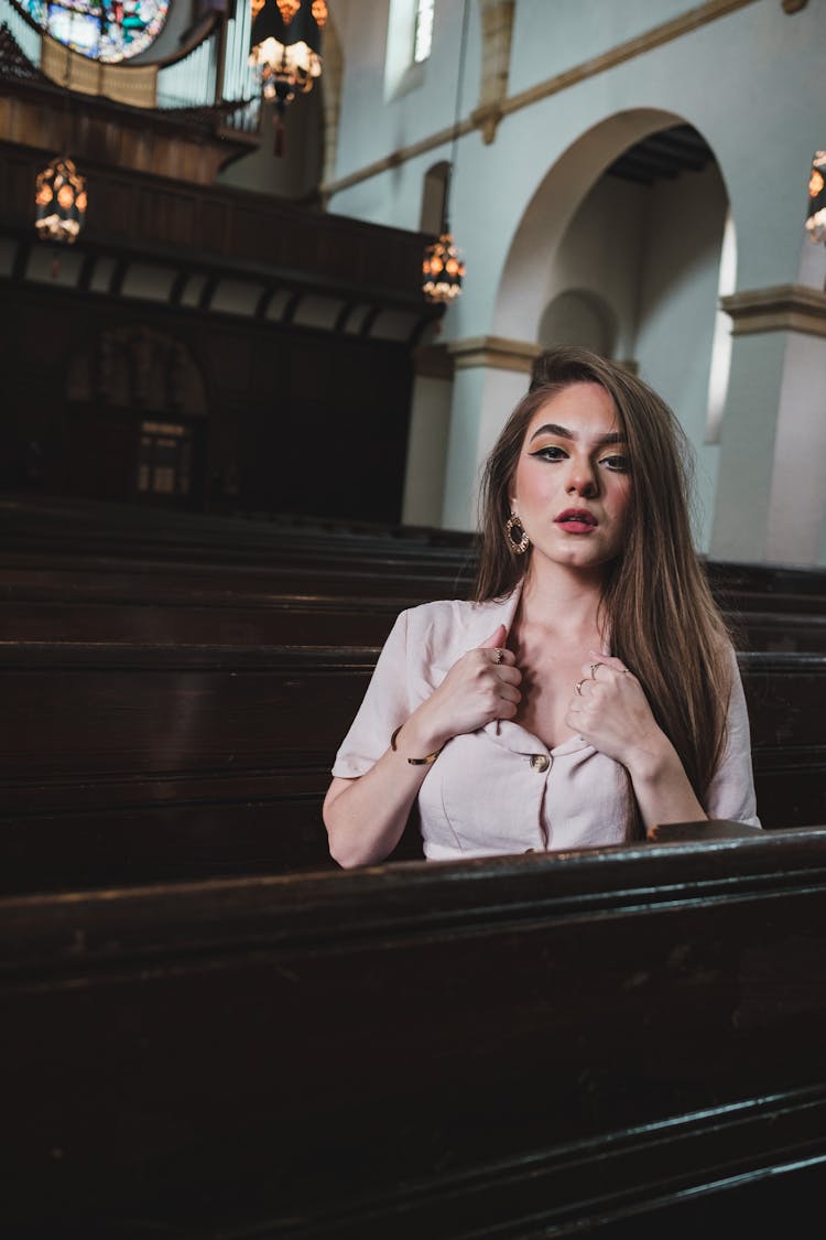 A Gorgeous Woman Holding The Collar Of Her Shirt