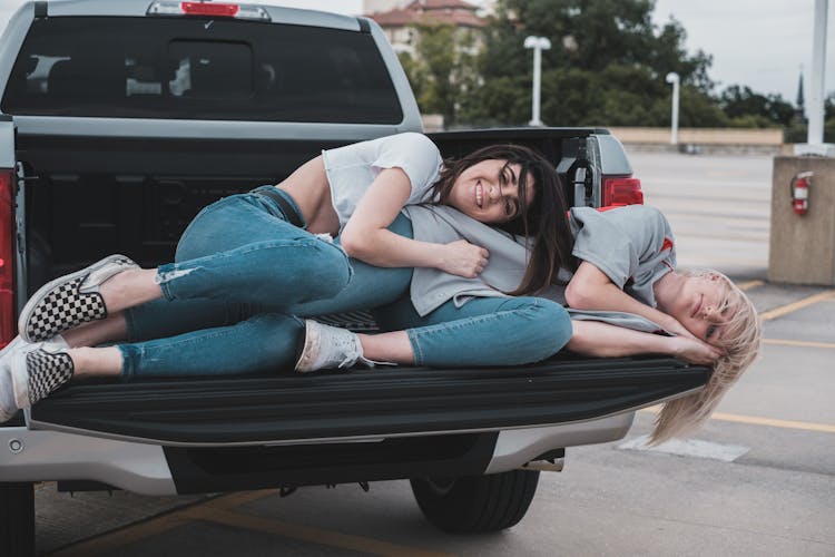 A Same Sex Couple Lying At The Back Of The Car