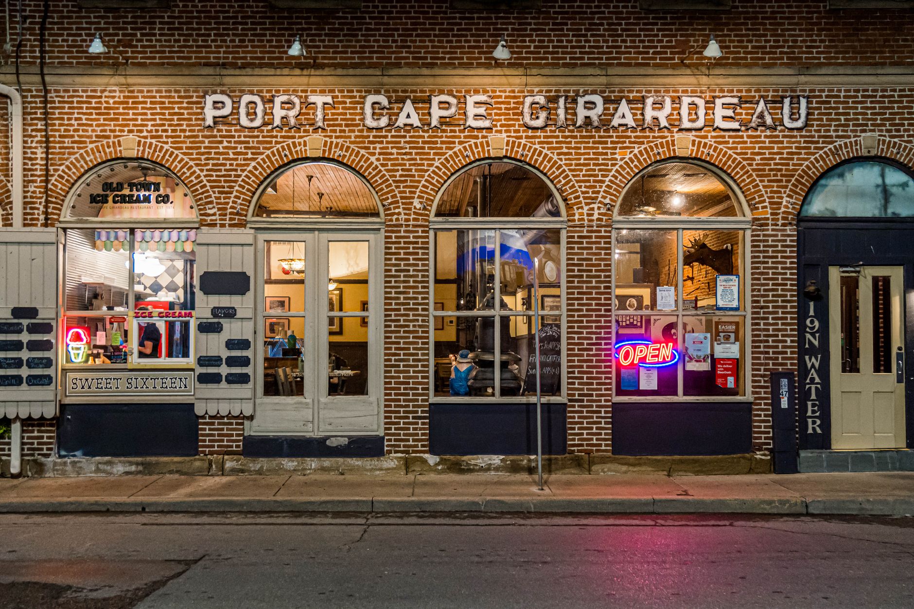 Charming ice cream shop in historic Port Cape Girardeau, MO, with neon signs glowing at night.