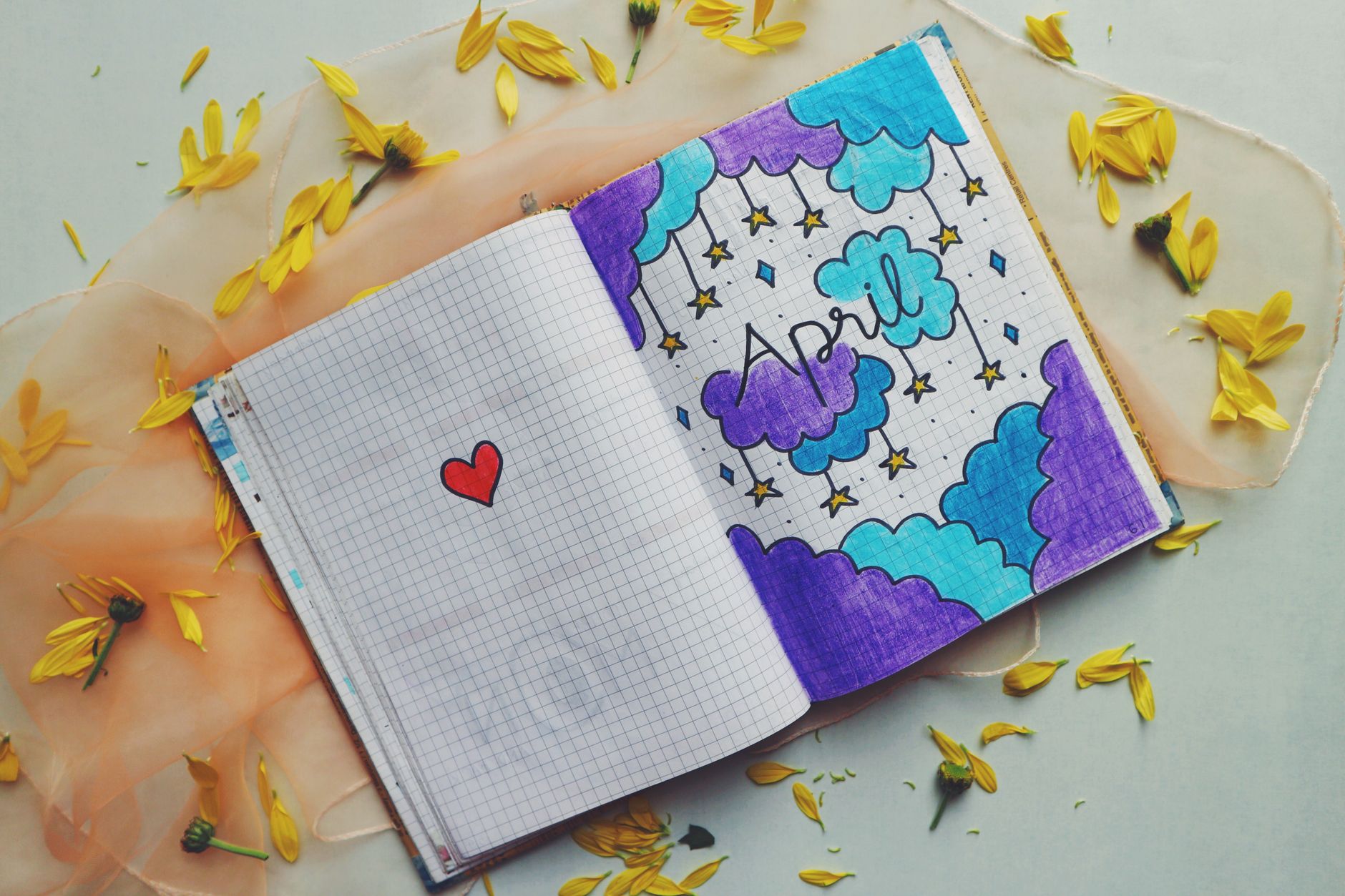 Artistic notebook page with April doodle surrounded by yellow petals.