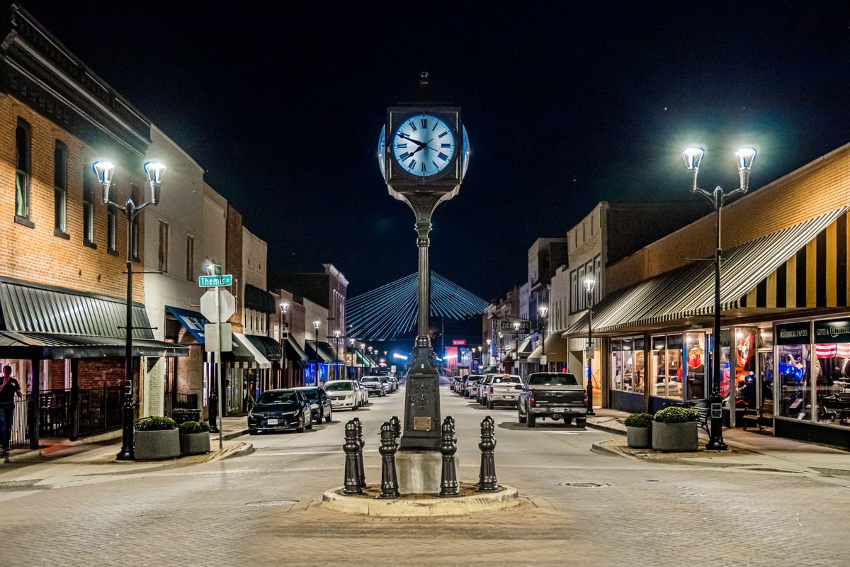 Historic downtown streetscape illuminated by a classic street clock at night