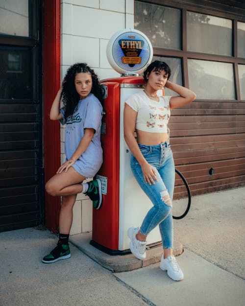 Women leaning on retro gasoline pump